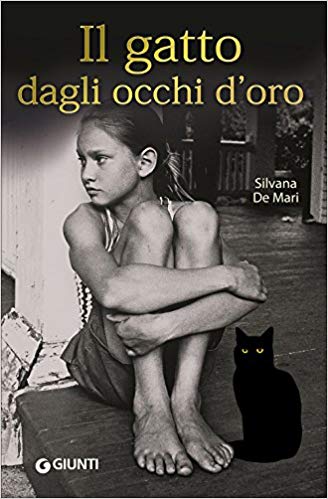 Foto di bambina seduta con le gambe tra le braccia e gatto nero