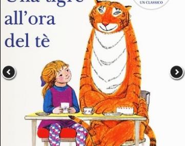una bambina e una tigre sedute a un tavolino con delle tazzine